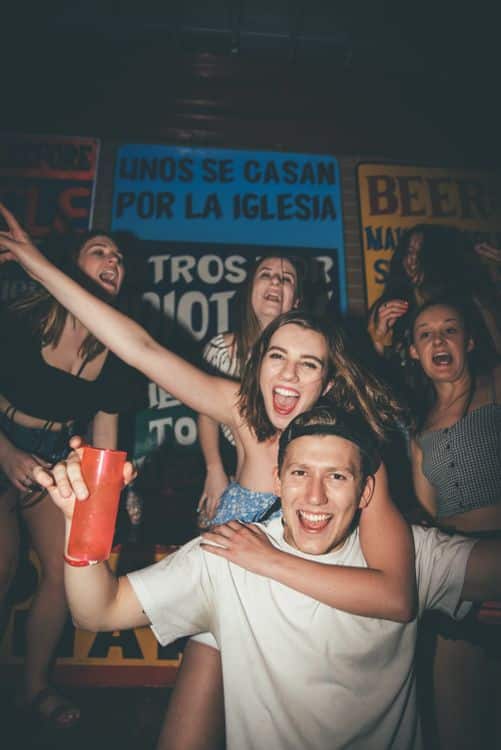 Young adults enjoying an indoor party with colourful lighting