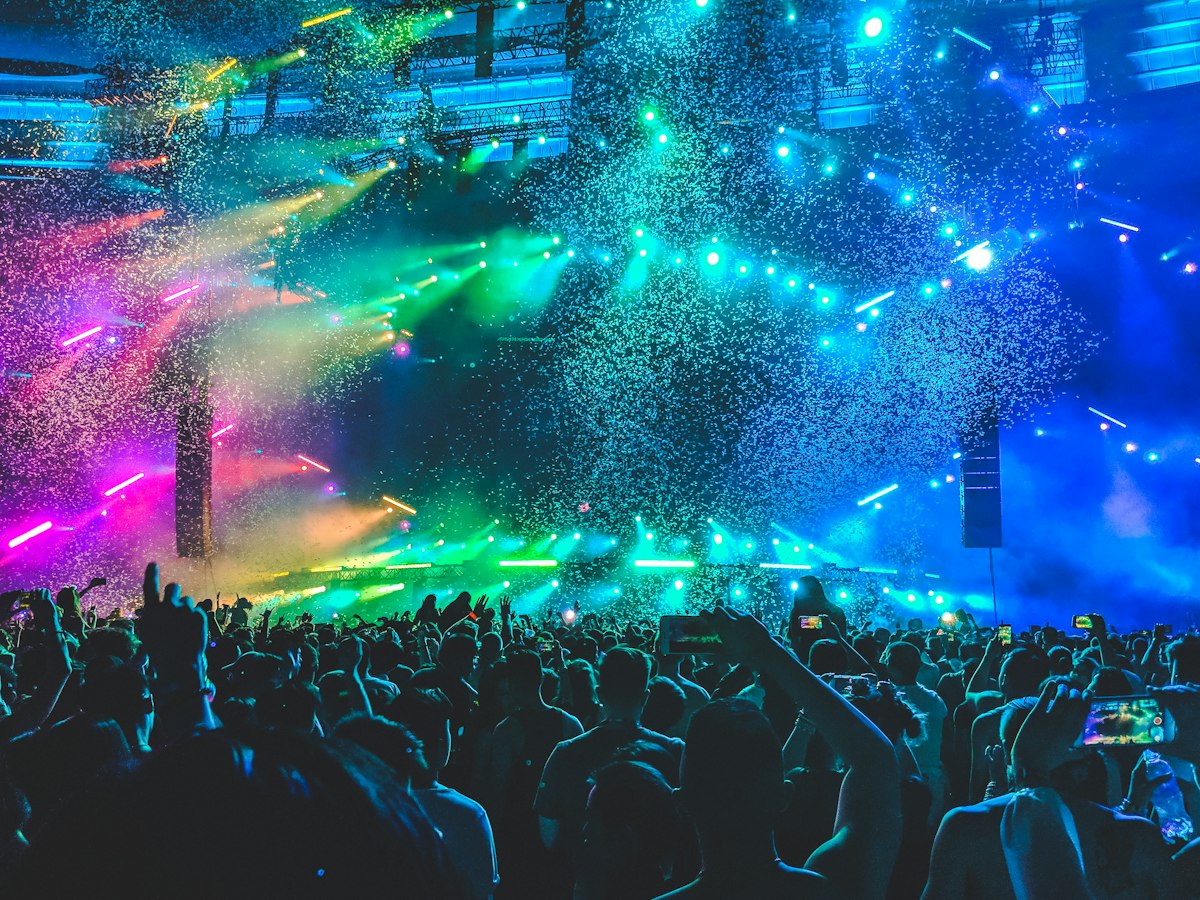 Crowd with raised hands at a club event under dramatic lighting