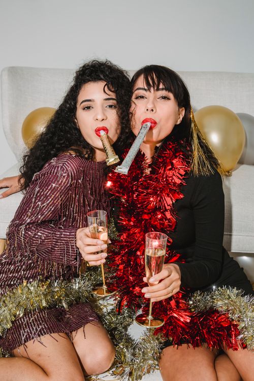 Two young women celebrating with champagne glasses at a festive hen party gathering